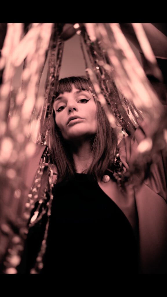  
Maren Montauk im Interview mit Pure Note


 
Clemens:  Wer bist du – und wo kommst du her?

Maren Montauk:  Ich bin Maren Montauk – geboren im Ruhrgebiet, zwischen Zechen, Beton und dem unzerstörbaren Überlebenswillen der Leute dort. Ich lebe in Berlin – und seit Corona wieder teils im Pott. Heimat bleibt ein fließender Zustand.

Clemens:  Wie würdest du deine Musik beschreiben? 

Maren Montauk: Schwer zu sagen. Ich höre oft: „Du klingst wie Kate Bush, erinnerst an Tori Amos oder Bowie“ – und dann kommt jemand und sagt: „Du bist wie Nina Hagen auf LSD“. Vielleicht stimmt alles ein bisschen. Vielleicht auch nichts. Hört einfach selbst rein – Maren Montauk ist eine Welt für sich.

Clemens:  Was inspiriert dich? 

Maren Montauk: Unsere Welt da draußen – das Schöne, das Schreckliche, das Wilde, das Absurde. Mythen, Menschen, Fantasien. Alles wird zur Bühne. Jeder Song ist für mich ein kleines Theaterstück, in dem ich Rollen durchlebe, die das Leben mir (noch) nicht gegeben hat. Musik ist mein Ventil, meine Rüstung und mein Tagebuch. Hier darf ich alles sein. Hier kann ich alles machen.

Clemens:  Gibt es künstlerische Ziele, die du verfolgst? 

Maren Montauk: Klar. Ich träume von einem eigenen Festspielhaus – ein Ort, an dem Musik, Theater, Performance und Film miteinander verschmelzen. Kein Genre, kein Dogma – nur Ausdruck. Das ist die große Vision.

Clemens:  Was bedeutet dir die Teilnahme an der Female Fall II-Reihe im Pure Note? 

Maren Montauk: Enorm viel. Es ist überfällig, dass Veranstalter gezielt Räume für Künstlerinnen schaffen. Frauen tragen in dieser Gesellschaft so viele Rollen – Care-Arbeit, Job, Kunst, Leben – und bekommen oft weniger Sichtbarkeit und Anerkennung. Diese Reihe zeigt: Female Art ist vielstimmig, mutig, relevant. Und sie ist längst keine Randerscheinung mehr.

Clemens:  Kanntest du das Pure Note vorher? 

Maren Montauk: Meine Schwester lebt in Düsseldorf – sie hat mir erzählt: „Da gibt’s diesen tollen Laden mit gutem Essen und Live-Musik, da musst du mal spielen!“ Jetzt bin ich Teil der Female Fall II-Reihe – und das fühlt sich genau richtig an.

Clemens:  Was macht diesen Ort für dich besonders? 

Maren Montauk: Dass hier Haltung spürbar wird. Nachhaltigkeit, Qualität – nicht nur auf dem Teller, sondern auch in der Kultur. Pure Note lebt das, was viele nur predigen.

Clemens:  Wie nimmst du die aktuelle Situation in der Musik- und Kulturszene wahr? 

Maren Montauk: Die Szene kommt langsam wieder auf die Beine. Es ist viel Wille und Mut da – aber auch eine gewisse Erschöpfung. Ich wünsche mir mehr Wertschätzung – von Politik, Gesellschaft, Medien. Kultur ist kein Luxus. Sie ist Nahrung. Für die Seele. So essenziell wie ein Dach über dem Kopf oder ein Teller Suppe.

Clemens:  Warum sollten Menschen zu deinem Konzert kommen?

 Maren Montauk: Weil es keine Show ist, sondern Begegnung. Ich will Verbindung schaffen – über Songs, Geschichten, Schwingungen. Für diesen einen Abend fallen Sorgen, Filter und Fassaden. Was bleibt, ist Präsenz. Gänsehaut. Ich teile, was mich bewegt – und das Publikum spiegelt es mir zurück. Das ist Musik. Das ist Magie.




 
Interview geführt von Marcel Clemens - Pure Note Düsseldorf - 2023

 
Photo by Robert Dyhringer